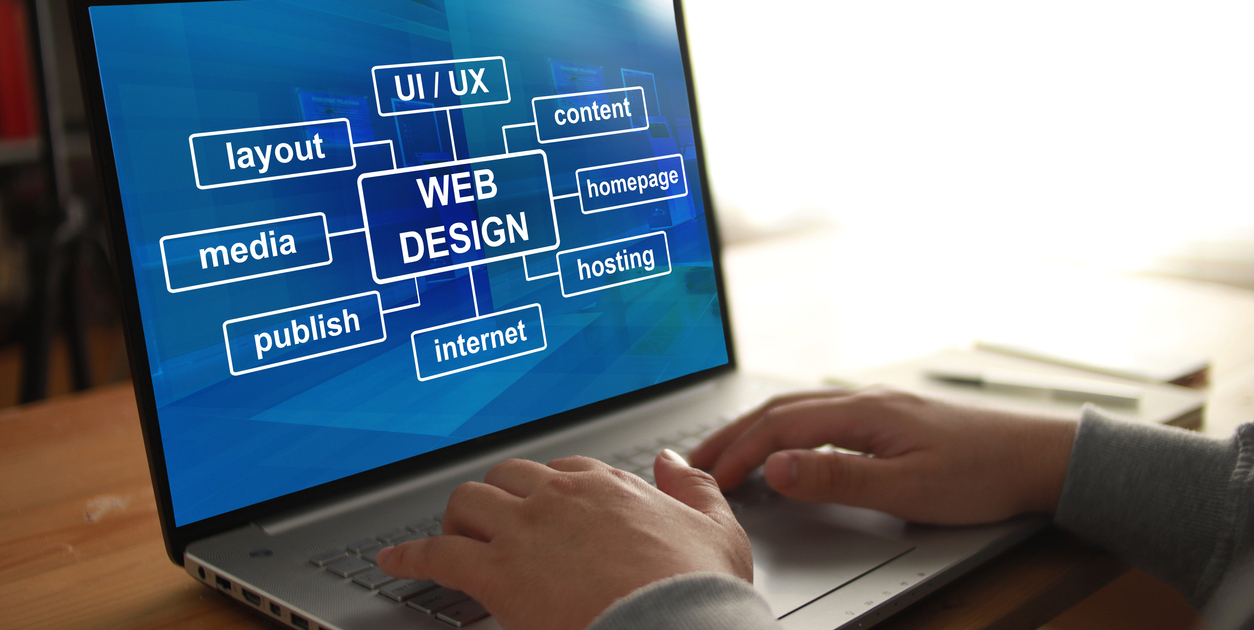 Anonymous person typing on laptop with web design program displayed on screen. UI UX website layout design