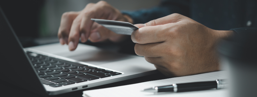 Guy entering CC information into his laptop