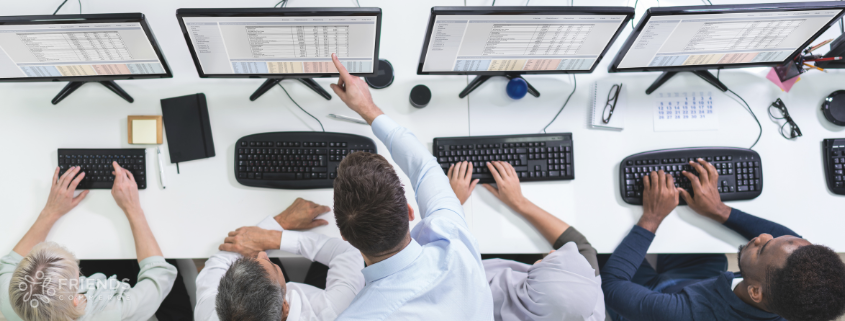 People working on workstations pointing at the screen